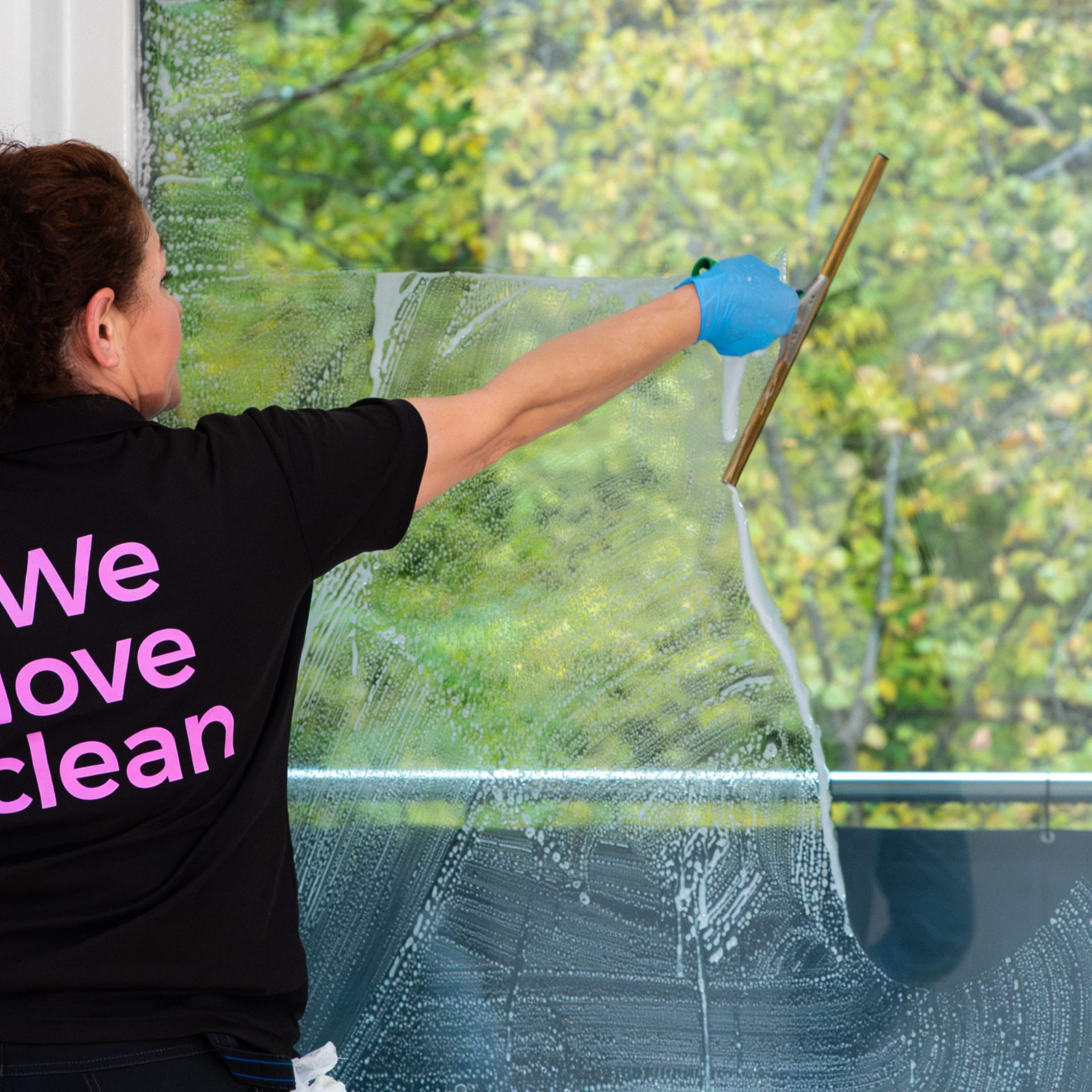Kvinna från städföretaget Fix Clean putsar fönster.